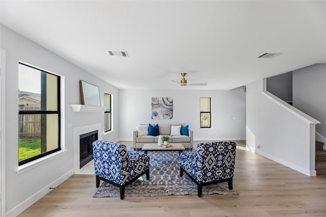 living room with light hardwood / wood-style flooring and ceiling fan