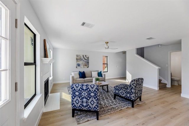 living room with ceiling fan, a healthy amount of sunlight, and light hardwood / wood-style floors