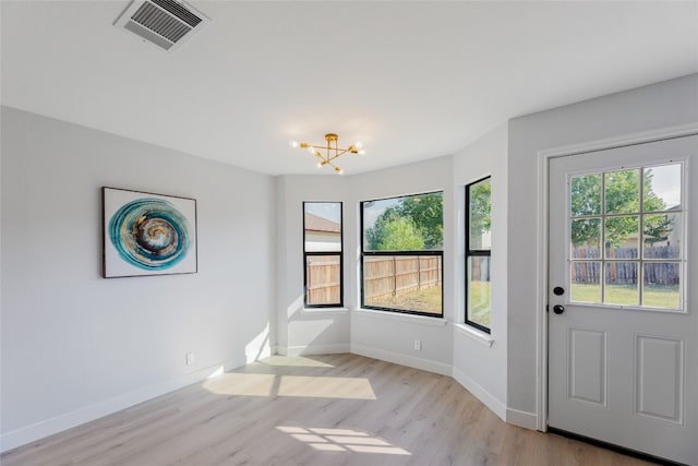 interior space with light hardwood / wood-style flooring and an inviting chandelier