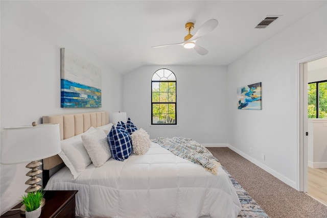 bedroom featuring multiple windows, ceiling fan, light carpet, and lofted ceiling