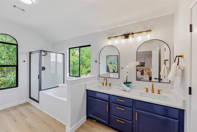 bathroom with vanity, hardwood / wood-style flooring, separate shower and tub, and lofted ceiling