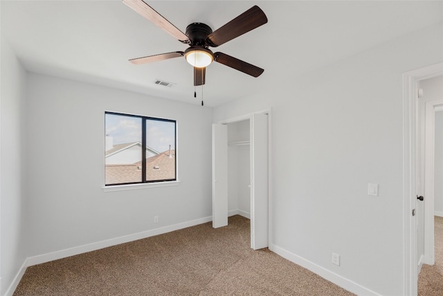 unfurnished bedroom with ceiling fan, a closet, and light carpet