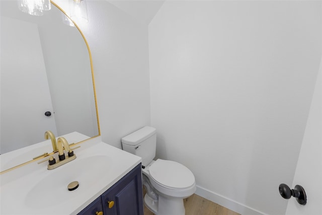 bathroom with hardwood / wood-style flooring, vanity, and toilet