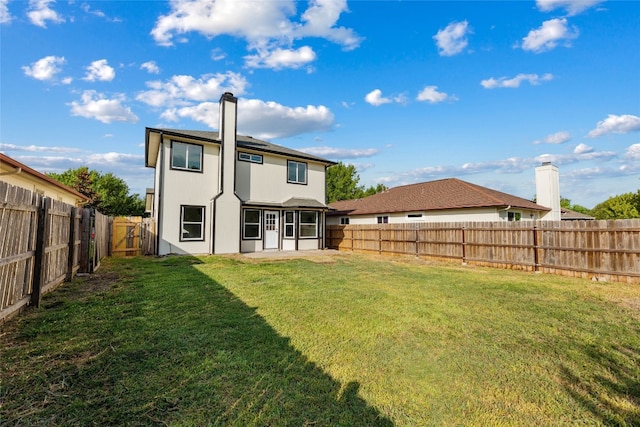 rear view of house with a lawn and a patio