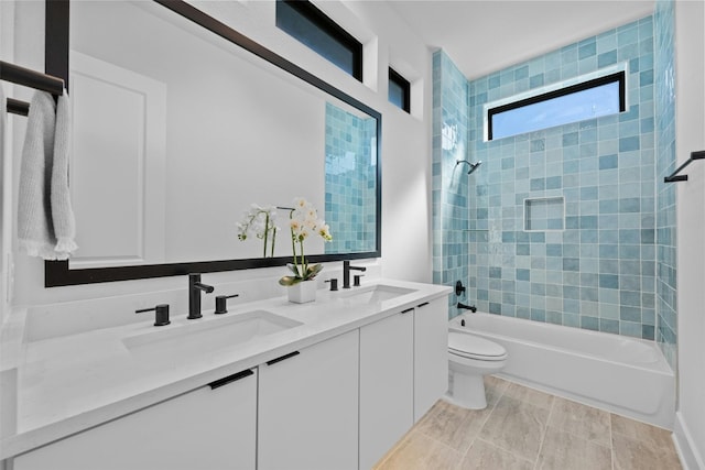 full bathroom with tile patterned flooring, vanity, toilet, and tiled shower / bath