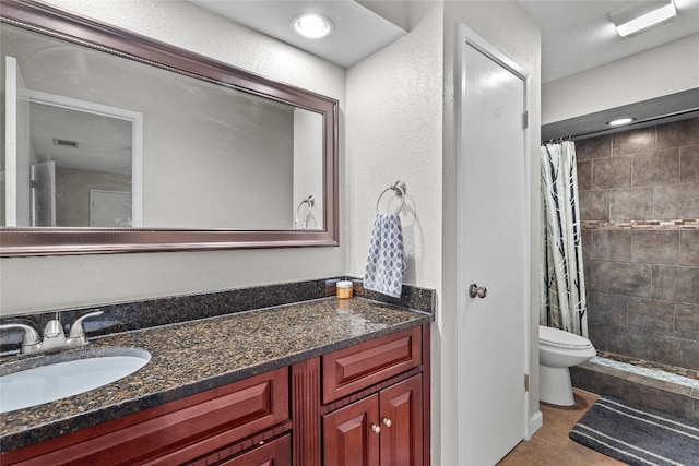 bathroom with tile patterned flooring, vanity, toilet, and walk in shower