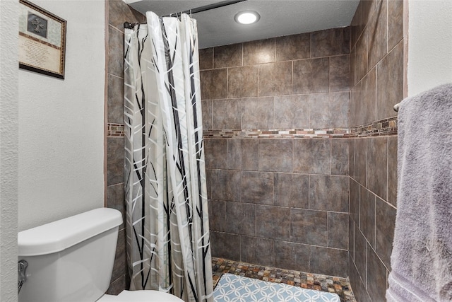 bathroom featuring a shower with curtain, a textured ceiling, and toilet