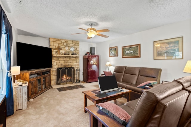 carpeted living room featuring a textured ceiling, ceiling fan, and a fireplace