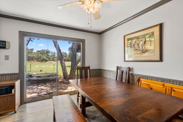 dining area featuring light wood-type flooring, crown molding, and ceiling fan