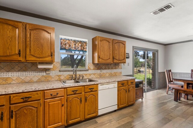 kitchen with a healthy amount of sunlight, sink, backsplash, and white dishwasher