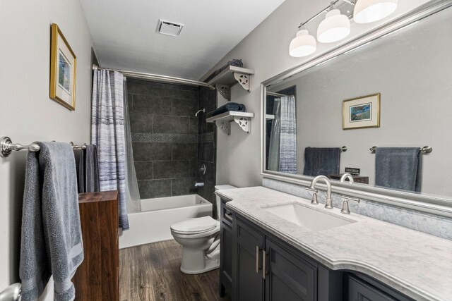 full bathroom featuring hardwood / wood-style flooring, toilet, oversized vanity, and shower / bath combo with shower curtain