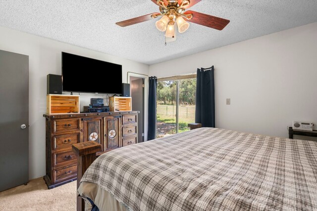 bedroom featuring light colored carpet, access to exterior, ceiling fan, and a textured ceiling