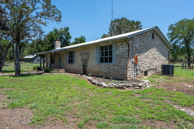 view of home's exterior with a lawn and central AC unit