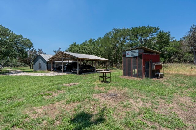 view of yard featuring a carport and an outdoor structure