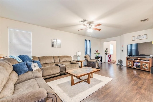 living room featuring ceiling fan and dark hardwood / wood-style floors