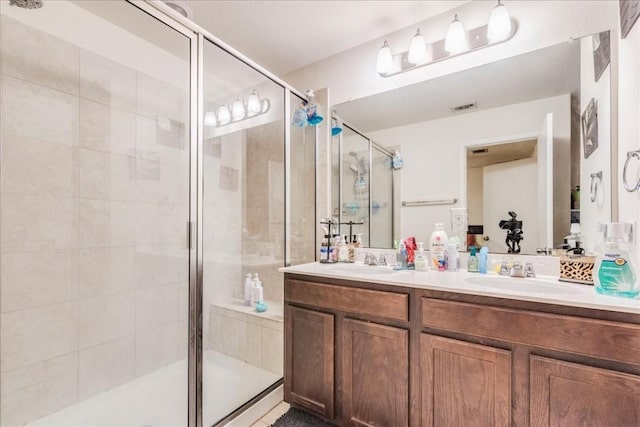 bathroom with vanity and a shower with door