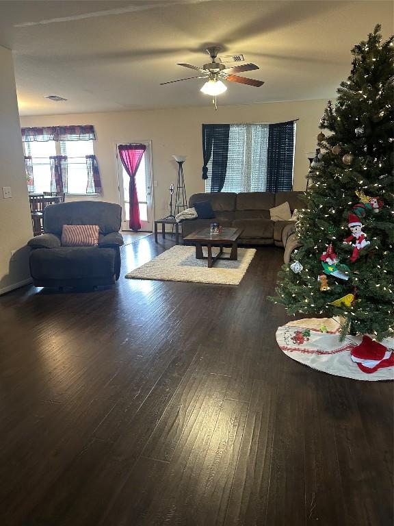 living room featuring ceiling fan and dark wood-type flooring