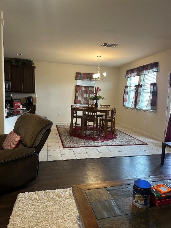 dining area featuring light hardwood / wood-style flooring and an inviting chandelier