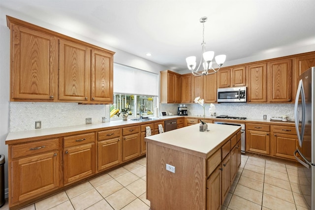 kitchen with sink, hanging light fixtures, appliances with stainless steel finishes, a notable chandelier, and a kitchen island