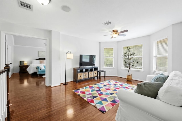 living room featuring ceiling fan and dark hardwood / wood-style floors