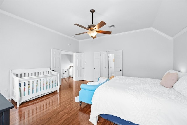 bedroom featuring ceiling fan, wood-type flooring, ornamental molding, and lofted ceiling