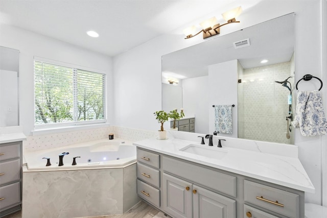 bathroom with hardwood / wood-style flooring, vanity, and plus walk in shower