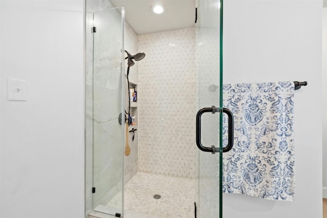 bathroom with a shower with door