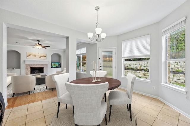 dining area featuring a wealth of natural light, light tile patterned flooring, and ceiling fan with notable chandelier