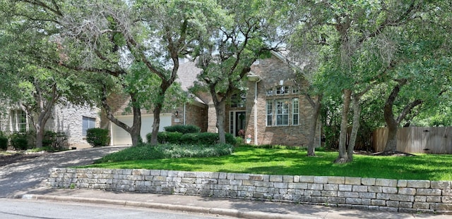 view of property hidden behind natural elements with a garage