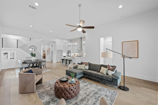 living room with light wood-type flooring and ceiling fan