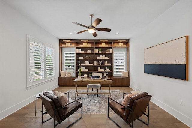 living area with wood-type flooring and ceiling fan