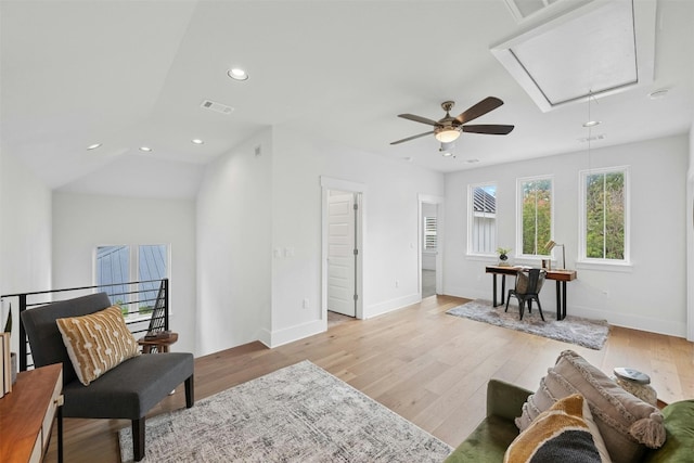 living area featuring light wood-type flooring, vaulted ceiling, and ceiling fan