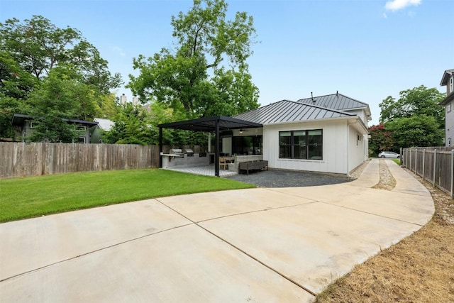 rear view of house with a yard, an outdoor hangout area, an outdoor kitchen, and a patio