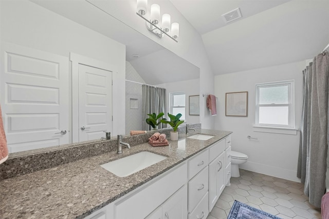 bathroom with tile patterned floors, vanity, a healthy amount of sunlight, and lofted ceiling