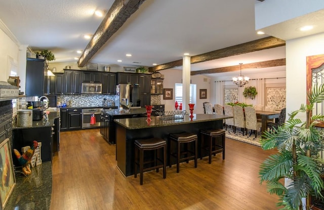 kitchen with a center island, dark hardwood / wood-style floors, beamed ceiling, a notable chandelier, and stainless steel appliances