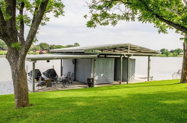 back of house featuring a water view and a yard