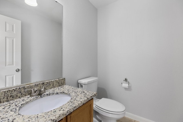 bathroom featuring tile patterned floors, vanity, and toilet