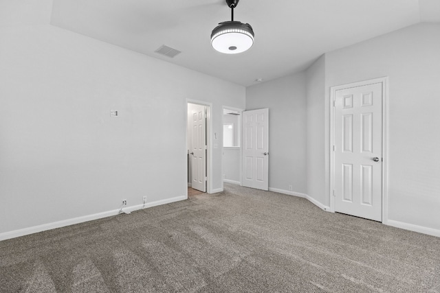 unfurnished bedroom featuring carpet and lofted ceiling