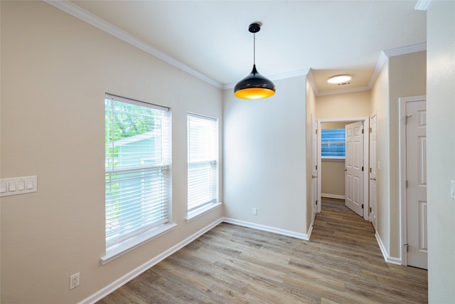 unfurnished dining area with ornamental molding, wood-type flooring, and a wealth of natural light