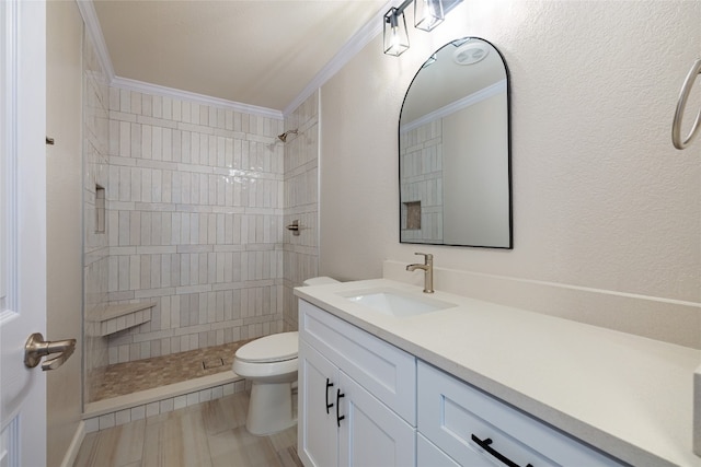 bathroom with vanity, toilet, ornamental molding, and a shower