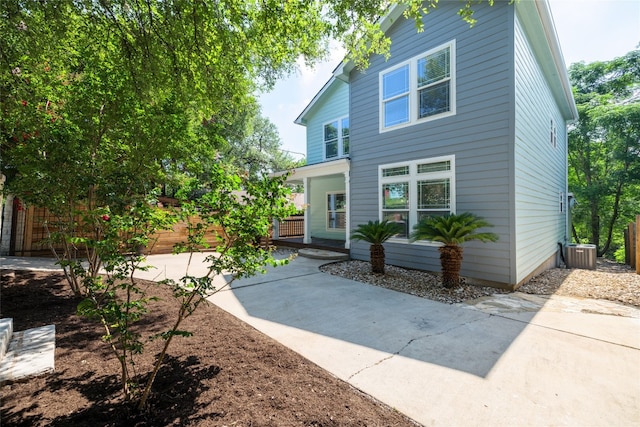 rear view of property featuring a patio area, fence, and central air condition unit