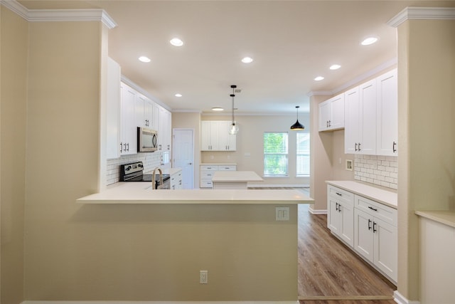 kitchen featuring stainless steel appliances, light wood-type flooring, tasteful backsplash, white cabinetry, and kitchen peninsula