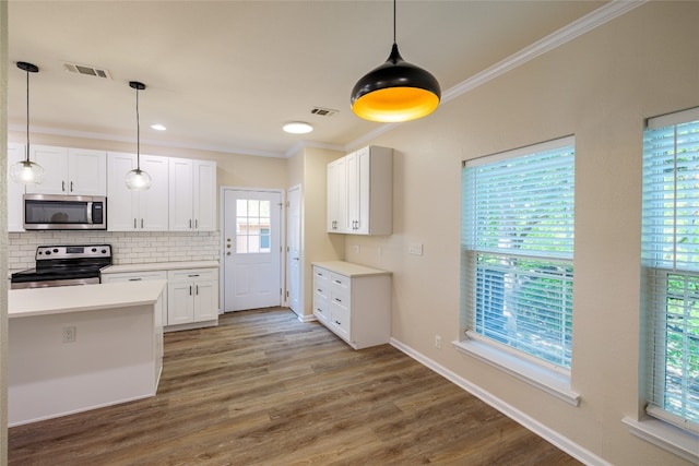 kitchen with appliances with stainless steel finishes, backsplash, hanging light fixtures, and hardwood / wood-style floors