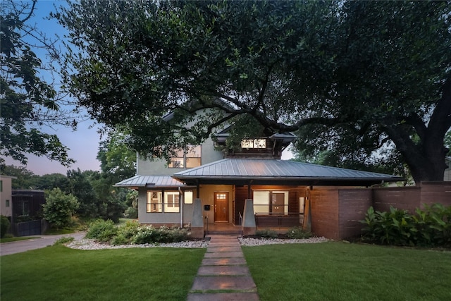 view of front of house featuring a lawn and covered porch