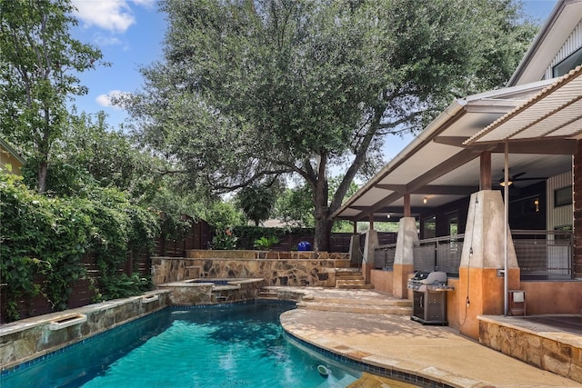 view of swimming pool with grilling area and an in ground hot tub