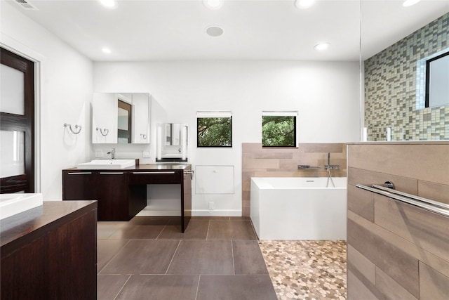 bathroom with vanity, tile walls, tile patterned floors, and a tub