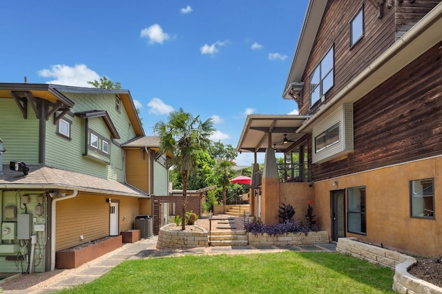 view of yard featuring central AC unit and a ceiling fan