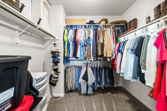 walk in closet featuring dark carpet