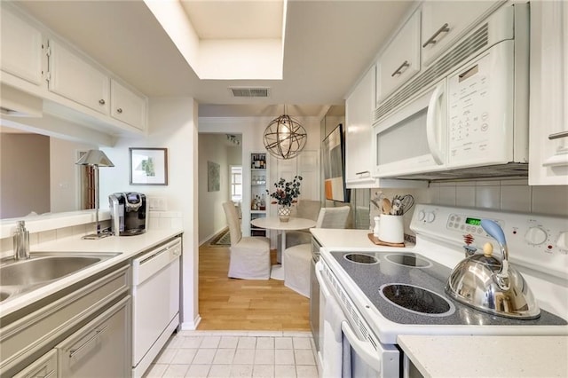 kitchen featuring light tile patterned floors, white appliances, white cabinetry, and sink