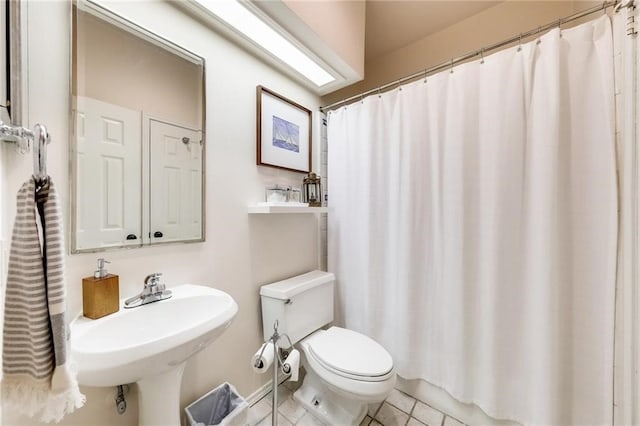 bathroom with tile patterned flooring, a shower with curtain, toilet, and sink